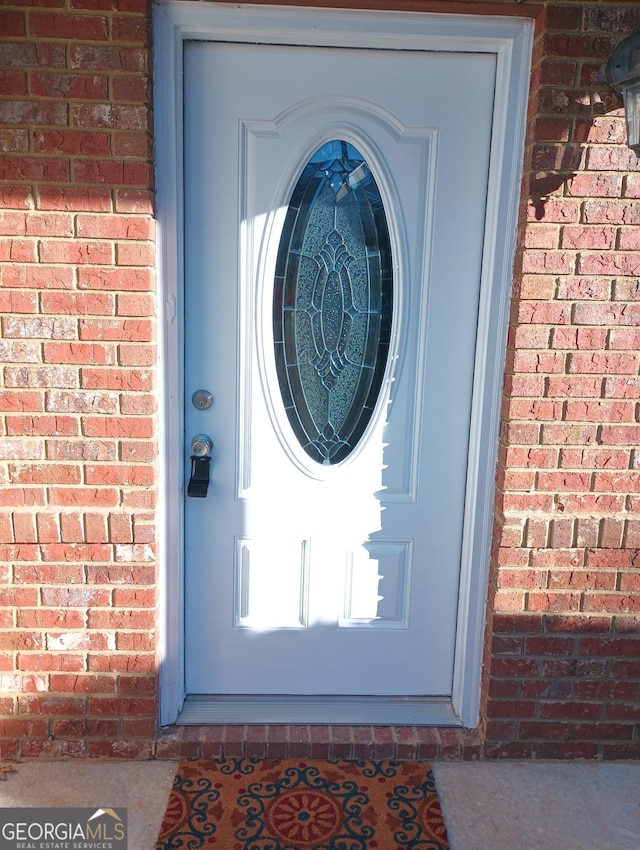 view of exterior entry featuring brick siding