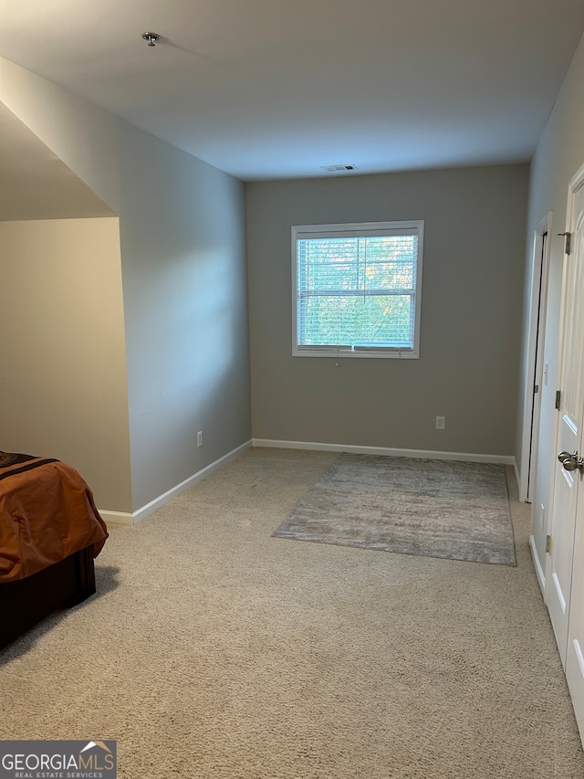 unfurnished bedroom featuring light carpet