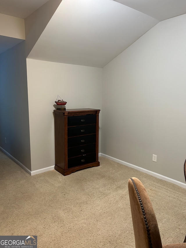 interior space featuring carpet floors and vaulted ceiling