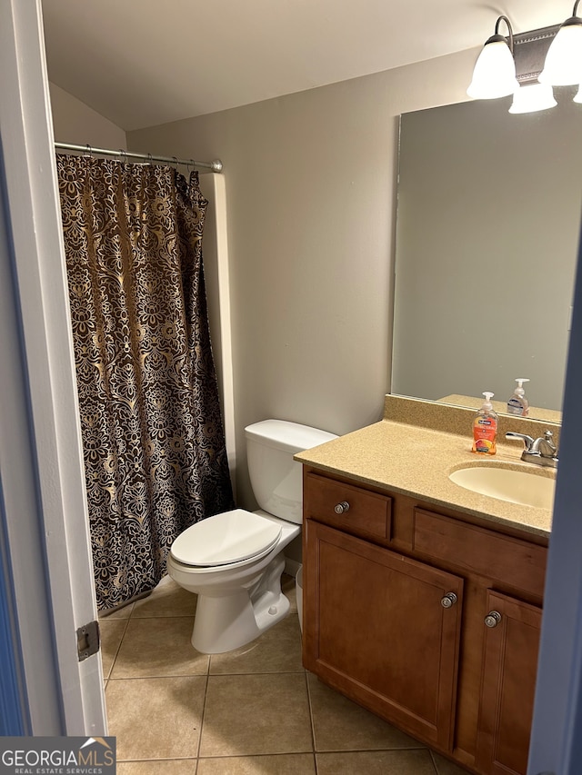 bathroom with tile patterned flooring, vanity, vaulted ceiling, and toilet