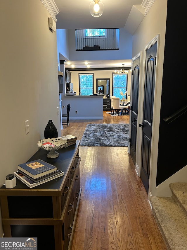 corridor featuring hardwood / wood-style floors, lofted ceiling, and a notable chandelier