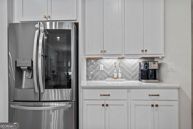 kitchen with white cabinets, decorative backsplash, and stainless steel fridge