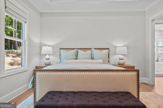 bedroom with light wood-type flooring and crown molding