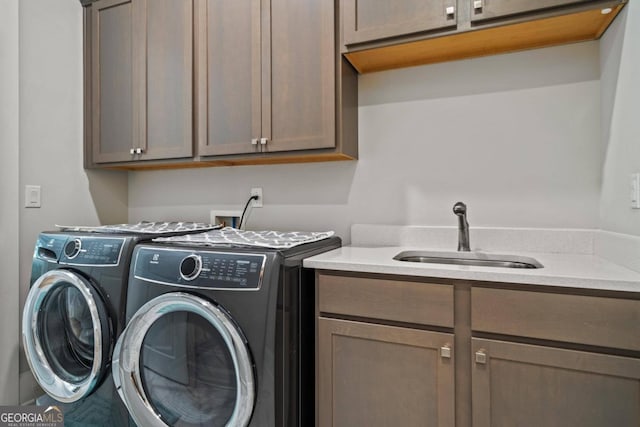 washroom featuring cabinets, independent washer and dryer, and sink