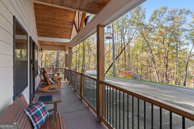 unfurnished sunroom featuring a healthy amount of sunlight, wood ceiling, and vaulted ceiling