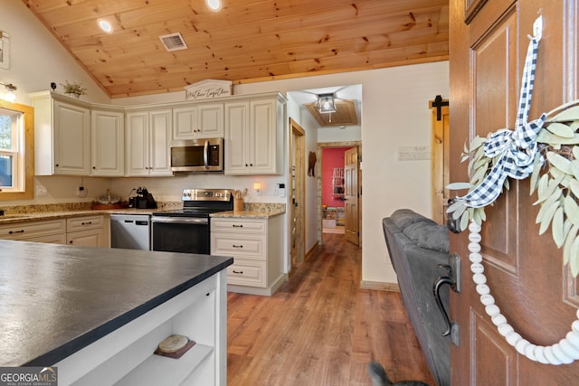 kitchen featuring light hardwood / wood-style floors, lofted ceiling, cream cabinetry, wood ceiling, and appliances with stainless steel finishes