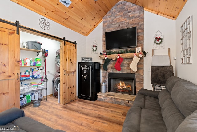 living room featuring stacked washer / dryer, wood ceiling, lofted ceiling, and hardwood / wood-style flooring