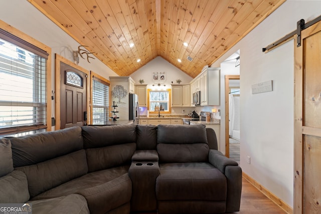 living room with sink, vaulted ceiling, a barn door, light wood-type flooring, and wood ceiling