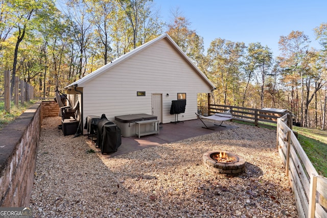 back of property featuring a patio area and a fire pit