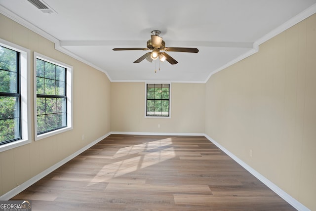 empty room with crown molding, plenty of natural light, and light wood-type flooring