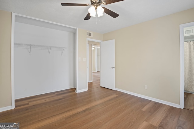 unfurnished bedroom with hardwood / wood-style flooring, ceiling fan, and a closet