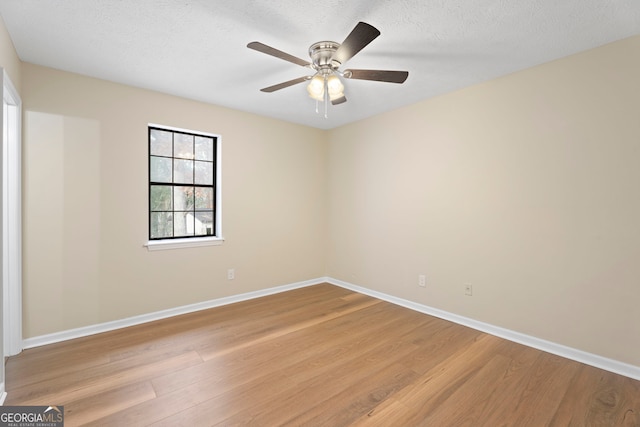 spare room with ceiling fan, a textured ceiling, and light wood-type flooring