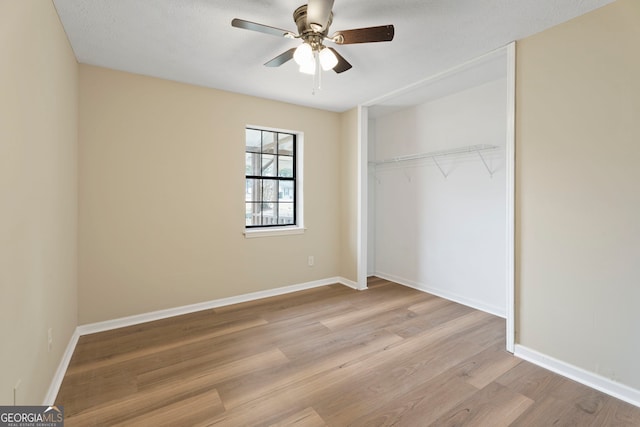 unfurnished bedroom with light hardwood / wood-style flooring, a closet, and ceiling fan