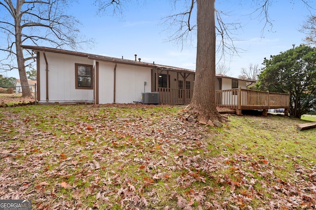 back of property with a wooden deck and a lawn