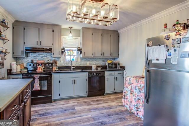 kitchen with light wood-type flooring, tasteful backsplash, crown molding, sink, and black appliances