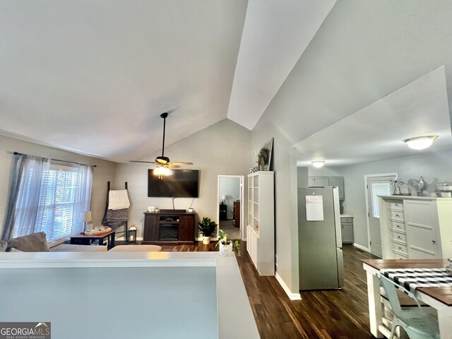 living room with ceiling fan, dark hardwood / wood-style flooring, and lofted ceiling