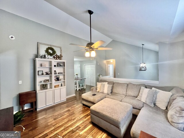 living room featuring hardwood / wood-style floors, high vaulted ceiling, and ceiling fan with notable chandelier