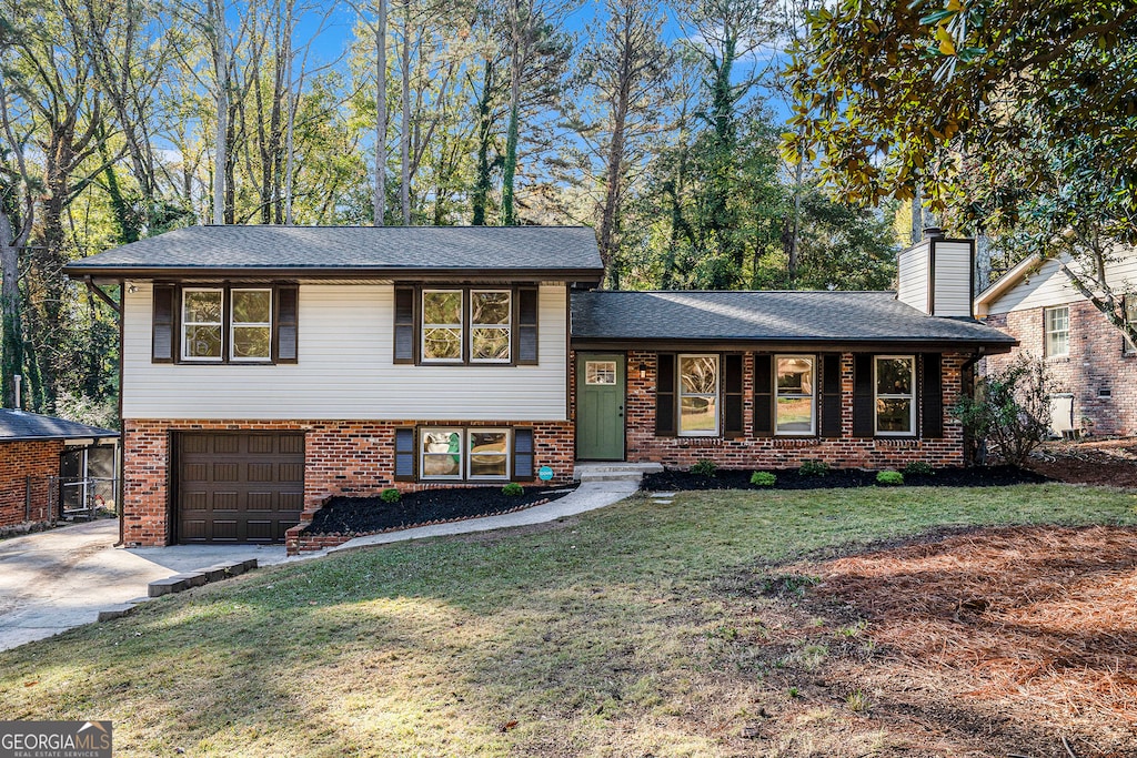 tri-level home featuring a front lawn and a garage