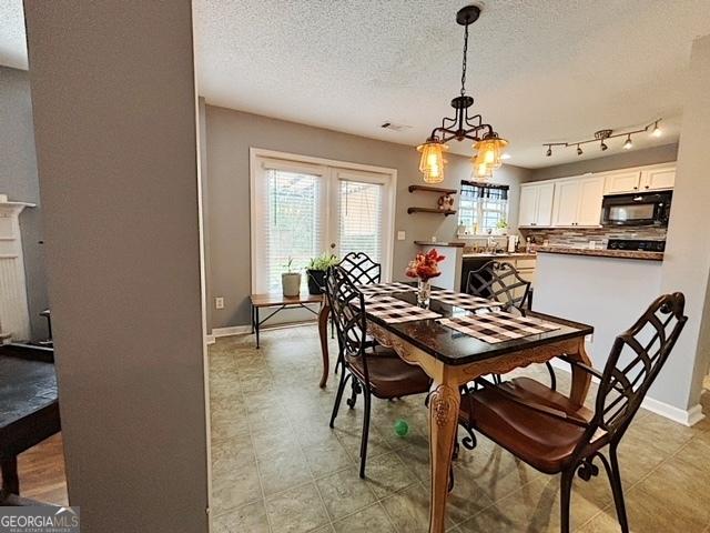 dining area featuring a textured ceiling and an inviting chandelier