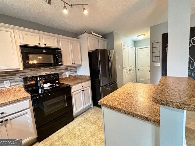 kitchen featuring a textured ceiling, white cabinetry, and black appliances