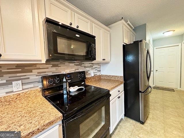 kitchen with decorative backsplash, white cabinets, a textured ceiling, light stone countertops, and black appliances