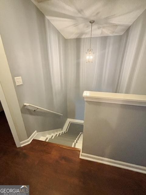 stairway with an inviting chandelier, carpet, and baseboards