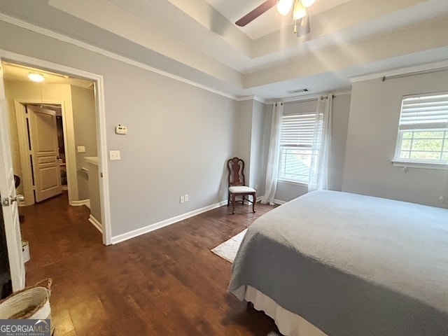 bedroom with a raised ceiling, ceiling fan, dark hardwood / wood-style flooring, and crown molding