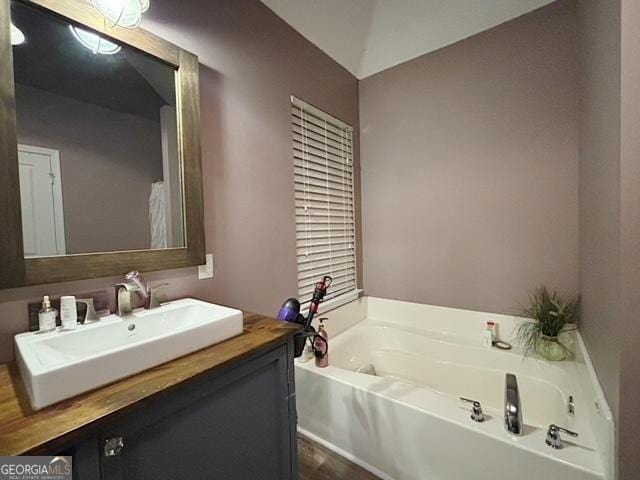 bathroom featuring a garden tub and vanity