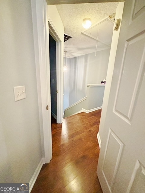 hallway featuring dark hardwood / wood-style flooring and a textured ceiling