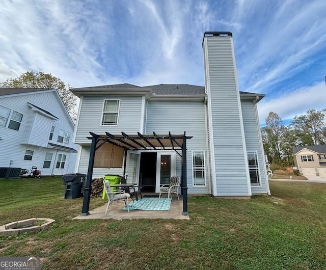 rear view of property featuring a chimney, a lawn, a patio area, and a pergola