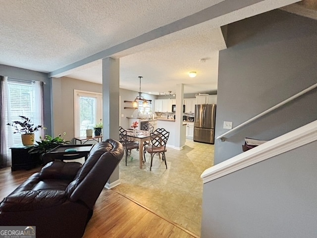 living room with a textured ceiling and light wood-type flooring