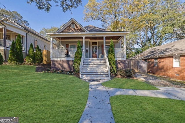 bungalow-style home featuring covered porch and a front yard