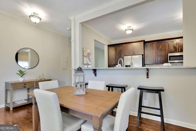 dining area featuring crown molding and dark hardwood / wood-style floors