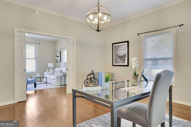 dining space with crown molding, hardwood / wood-style floors, and an inviting chandelier