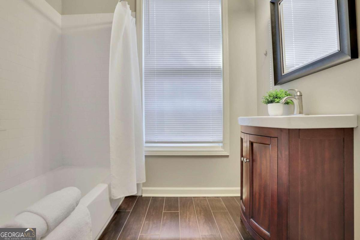 bathroom featuring vanity, wood-type flooring, and shower / tub combo