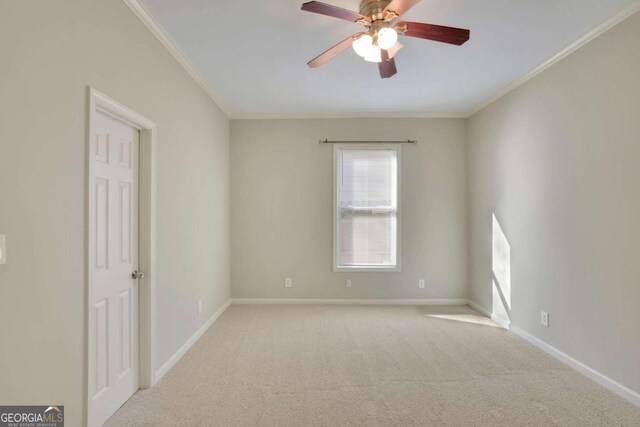 carpeted spare room with ceiling fan and ornamental molding