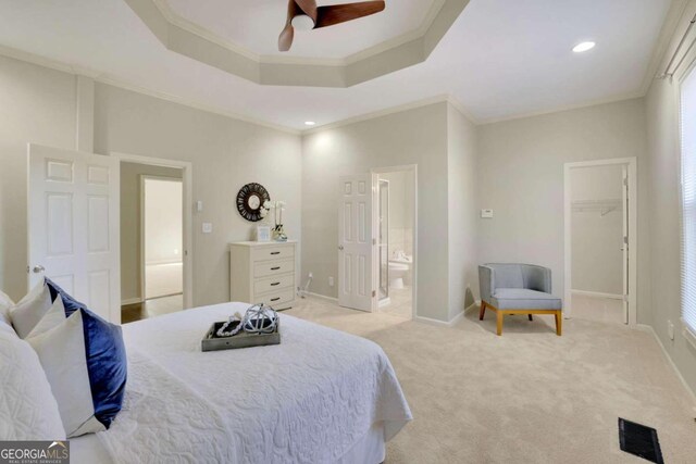 bedroom featuring a walk in closet, ceiling fan, ornamental molding, light colored carpet, and a closet