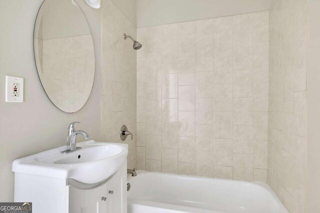 bathroom with vanity and tiled shower / bath combo