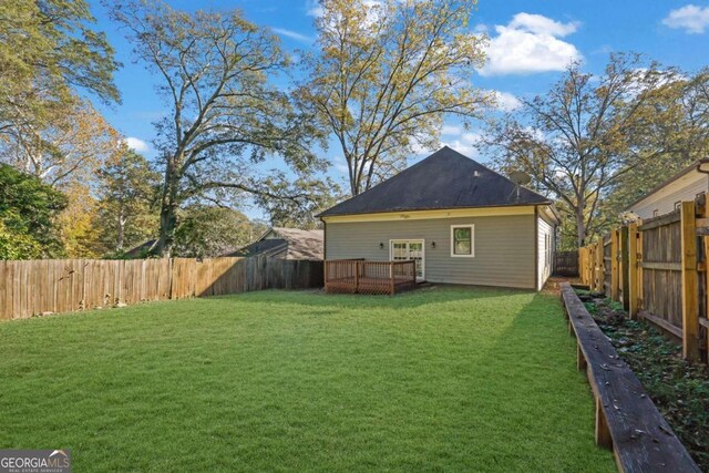 back of property featuring a lawn and a wooden deck