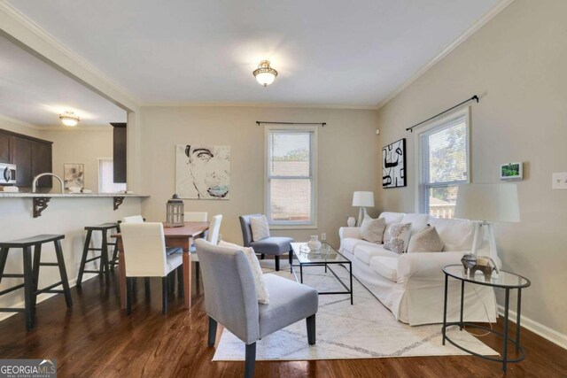 living room with plenty of natural light, dark hardwood / wood-style floors, and ornamental molding