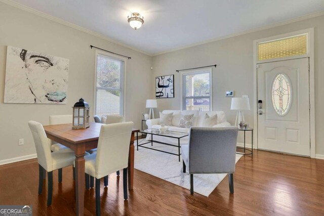 dining space with hardwood / wood-style floors and crown molding