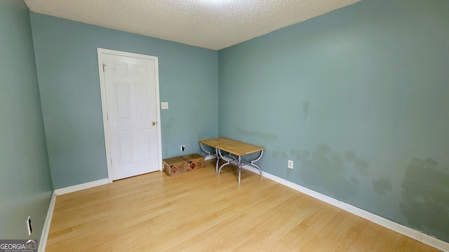 spare room with hardwood / wood-style floors and a textured ceiling