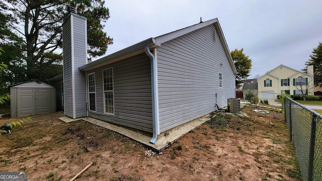 view of home's exterior with a shed and cooling unit