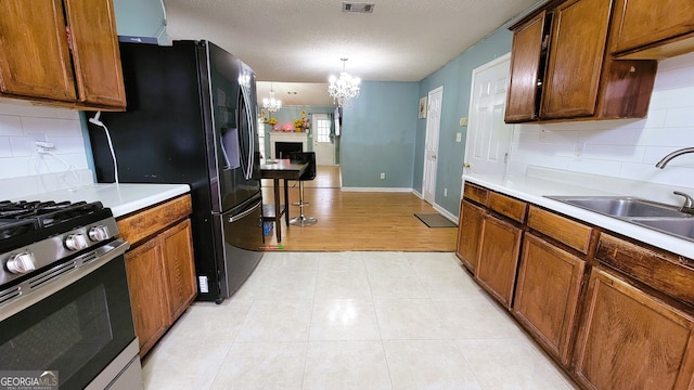 kitchen featuring decorative backsplash, sink, hanging light fixtures, and an inviting chandelier