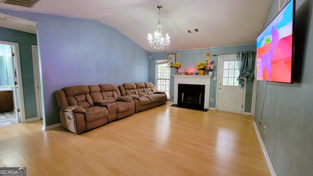 unfurnished living room with light hardwood / wood-style flooring, lofted ceiling, and a notable chandelier