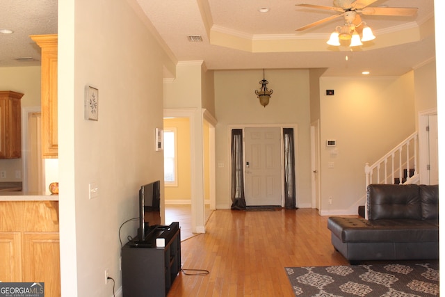 entryway with ceiling fan, light wood-type flooring, and crown molding