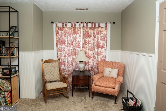 sitting room with carpet flooring and a textured ceiling