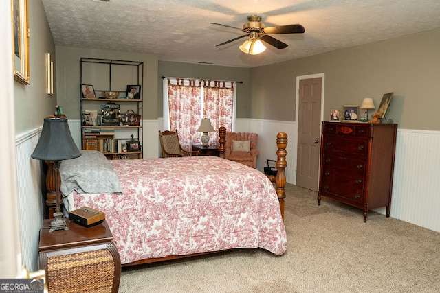 bedroom featuring a textured ceiling, carpet floors, and ceiling fan