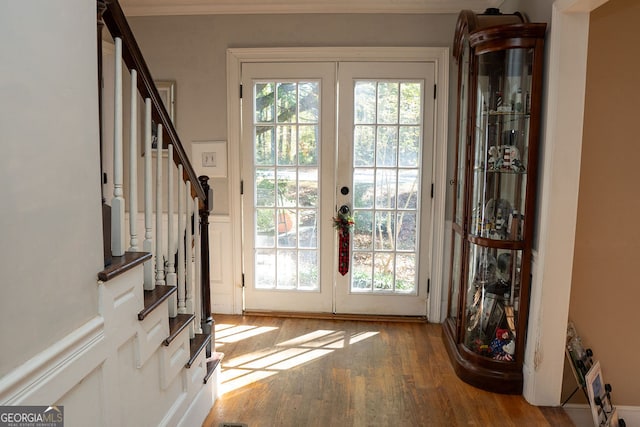 doorway to outside with hardwood / wood-style floors, ornamental molding, and french doors