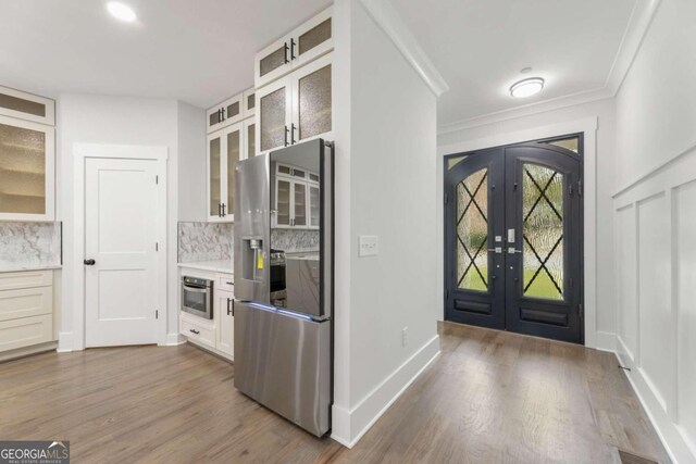 kitchen featuring french doors, backsplash, stainless steel appliances, dark hardwood / wood-style floors, and white cabinetry